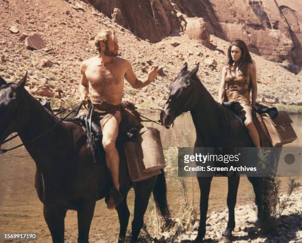 Linda Harrison as Nova and Charlton Heston as astronaut Taylor riding horses in a scene from the 1968 sci-fi film 'Planet of the Apes'.