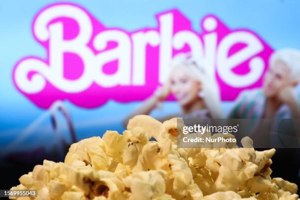 Popcorn and Barbie movie website displayed on a screen in the background are seen in this illustration photo taken in Krakow, Poland on August 1,...