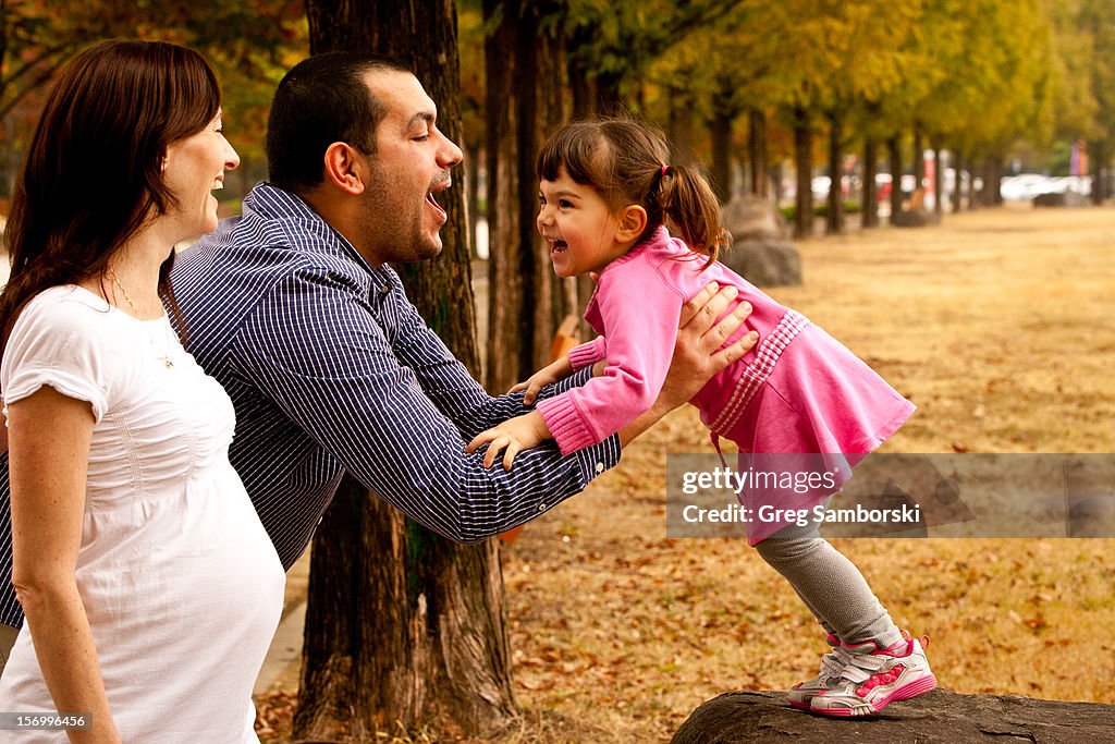 Father Picking Up Daughter Outside