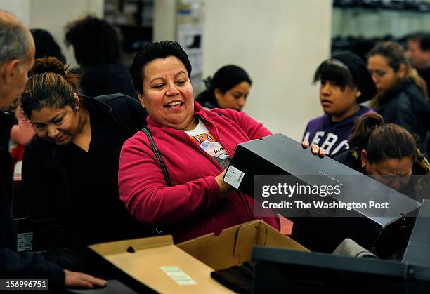 At the J.C. Penney store, Imelda Diaz of Landover, MD checks to find her size for some boots that normally sell for $65.00 but were on sale for...