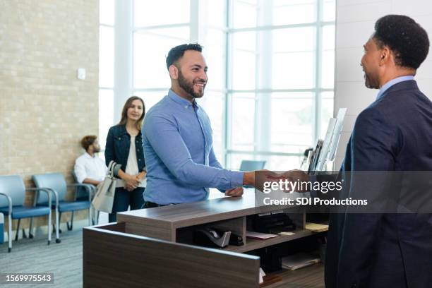 le banquier et l’homme d’affaires échangent des plaisanteries pendant la transaction - guichet de banque photos et images de collection