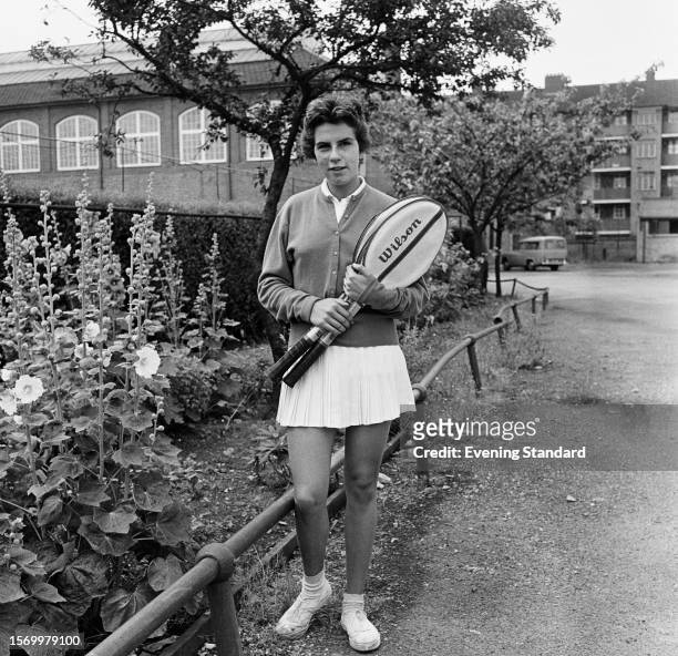 Brazilian tennis player Maria Bueno holding her rackets beside a flowerbed, July 3rd 1959. Bueno reached the Women's Singles final at Wimbledon.