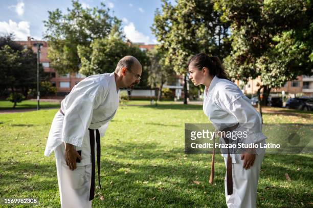 karate/taekwondo students bowing during class at public park - people showing respect stock pictures, royalty-free photos & images