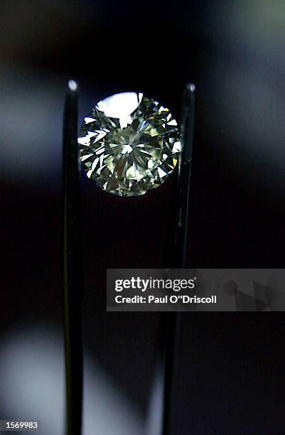 Diamond factory employee examines a diamond October 31, 2002 in Antwerp, Belgium. The gem traders in Antwerp are under pressure to regulate the sales...