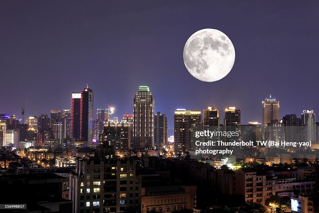 Full moon upon lights of city
