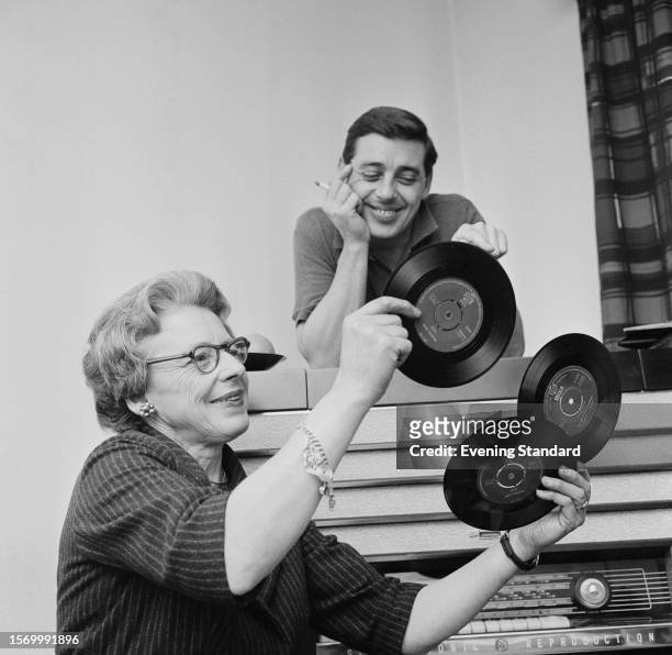 Pianist Joe "Mr. Piano" Henderson with his mother Mrs Henderson holding up three 45 vinyl records, January 12th 1960.