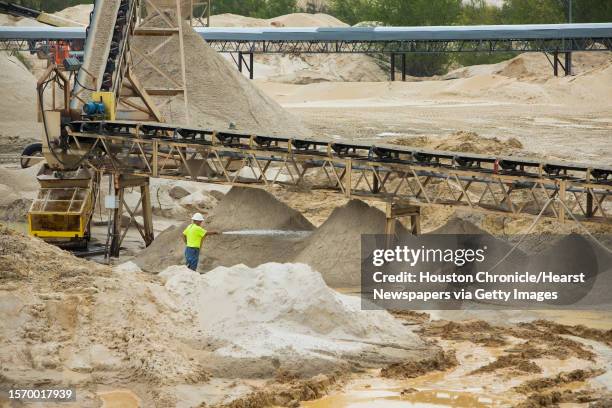 Worker sprays down piles of sand at the Superior Silica Sands sand mine on Tuesday, March 28 in Kosse, Texas. Demand for sand is surging as oil and...