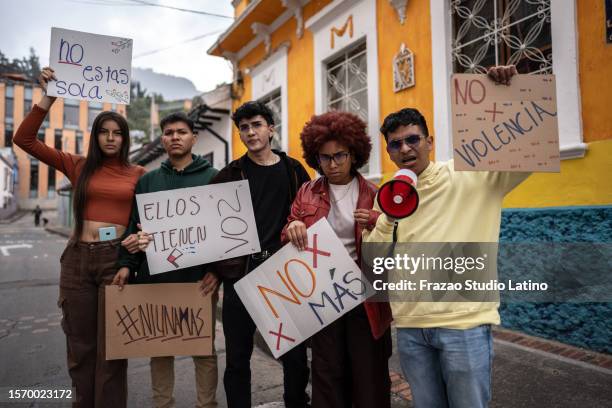 retrato de um jovem manifestante segurando faixas em uma manifestação contra a violência ao ar livre - social movement - fotografias e filmes do acervo