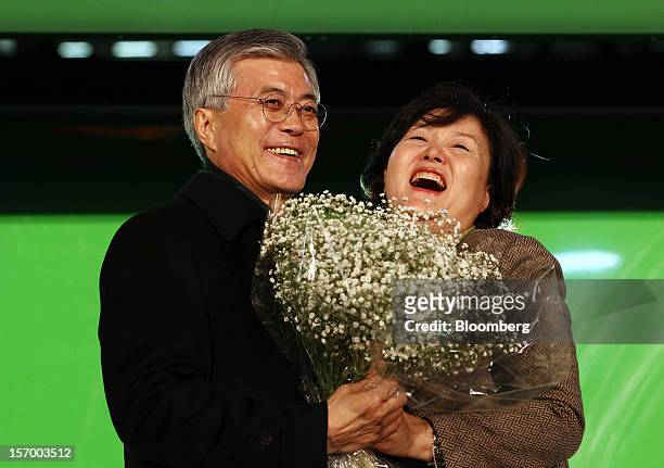 Moon Jae In, presidential candidate for South Korea's main opposition Democratic United Party, reacts with his wife, Kim Jeong-suk, during a campaign...