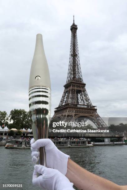 Participant holds the Olympic torch during it's presentation as part of a Pre-Olympic tour along the Seine on July 25, 2023 in Paris, France. On July...