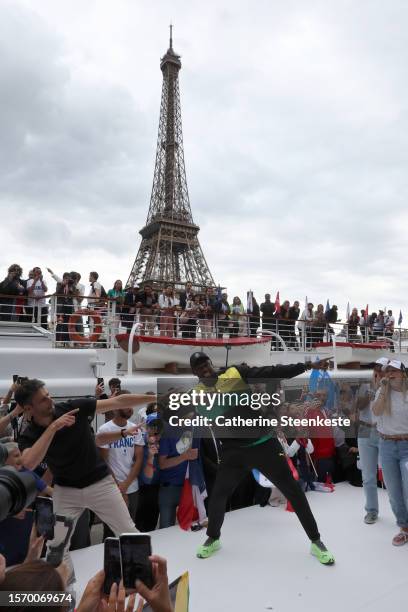 Tony Estanguet, President of Paris 2024, and former sprinter Usain Bolt pose during a Pre-Olympic tour along the Seine with the Eiffel Tower in the...