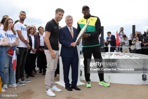 Tony Estanguet, President of Paris 2024, Thomas Bach, President of the International Olympic Committee and former sprinter Usain Bolt hold the...