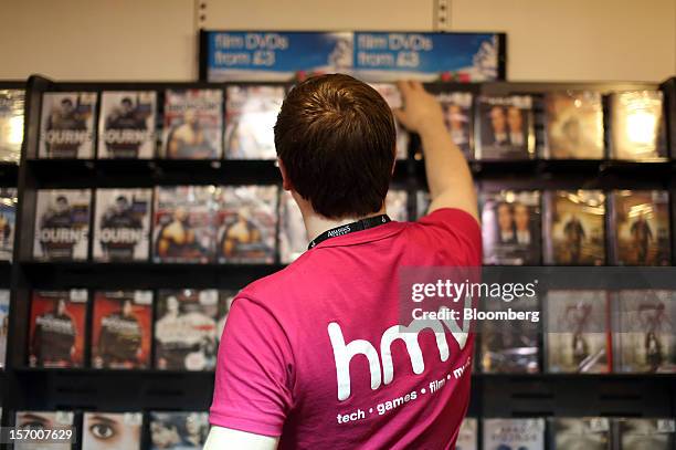 An employee re-stocks DVDs on to the display inside a HMV pop-up store, in this arranged photograph in London, U.K., on Tuesday, Nov. 27, 2012....