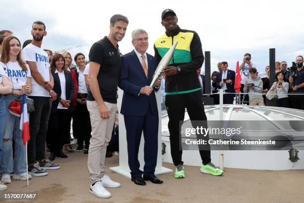 Tony Estanguet, President of Paris 2024, Thomas Bach, President of the International Olympic Committee and former sprinter Usain Bolt hold the...