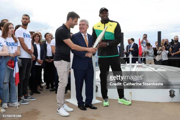 Tony Estanguet, President of Paris 2024, Thomas Bach, President of the International Olympic Committee and former sprinter Usain Bolt hold the...