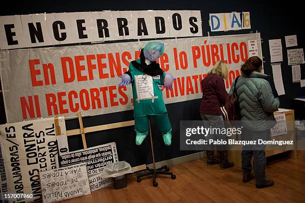 Health workers stand next a banner that reads 'Occupying 16 days in defence of the public service. No cuts. No privatizations' in an assembly room at...