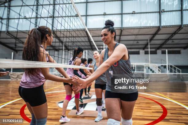 weibliche volleyballmannschaften begrüßen sich vor dem spiel auf dem sportplatz - fairness stock-fotos und bilder