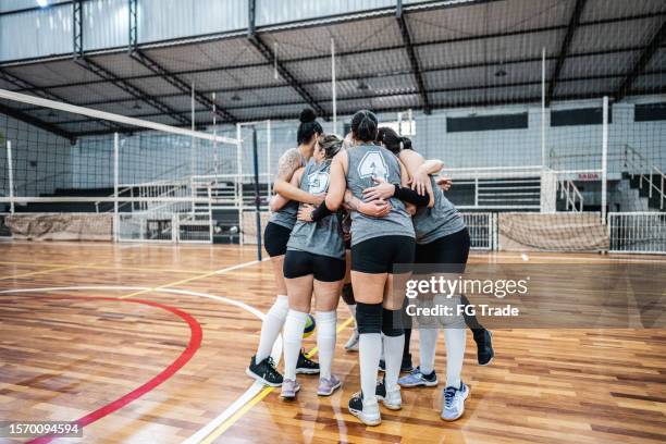 female volleyball team celebrating after win a match on the sports court - candid volleyball stock pictures, royalty-free photos & images