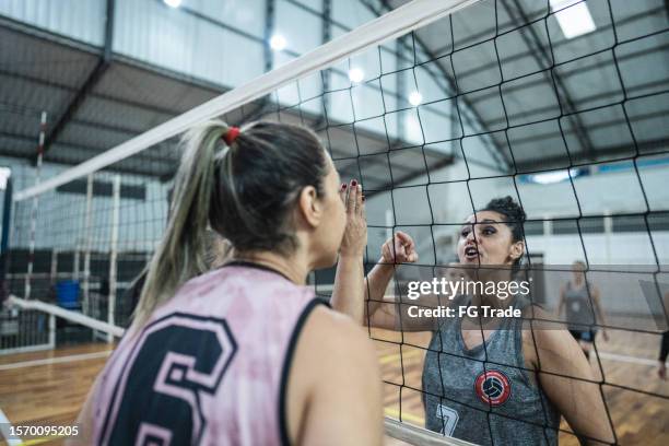 female volleyball player arguing with opposing team on the sports court - face off sports play stock pictures, royalty-free photos & images