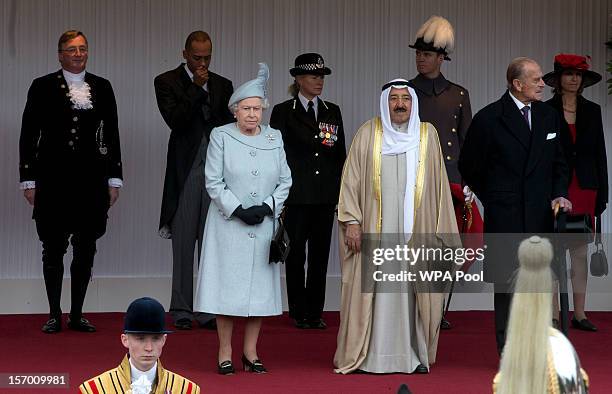 The Amir Sheikh Sabah Al-Ahmad Al-Jaber Al-Sabah of Kuwait and Queen Elizabeth II stand together as national anthems are played outside Windsor...