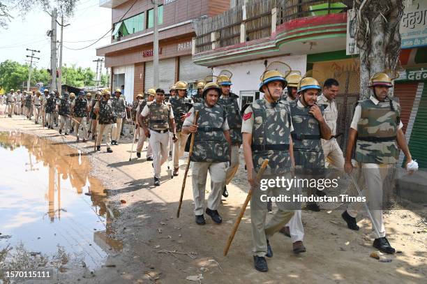 Police personnel conduct a flag march due to security reasons at Nuh near Bus Stand on August 1, 2023 in Nuh, India. Five people were killed and over...