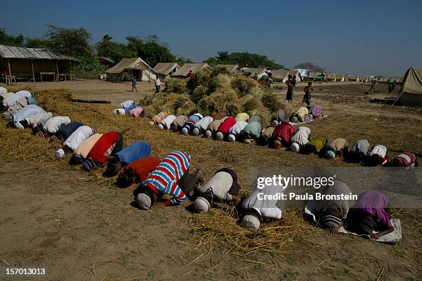 Rohingya boys pray during Friday prayer next to hay at a tented IDP camp November 23, 2012 on the outskirts of Sittwe, Myanmar. An estimated 111,000...