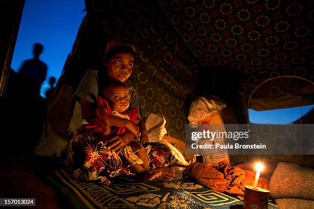 Aaisha sits in her tent with her 11 month old baby Bibi Aisha at a refugee tented camp for Rohingya IDP's November 23, 2012 on the outskirts of...