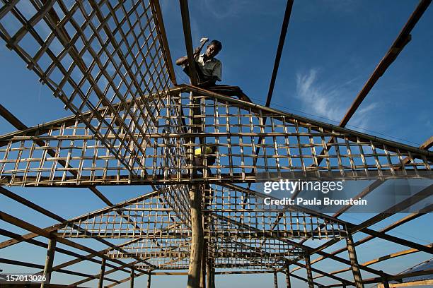 Worker builds new housing aimed at offering the Rohingya an alternative to the tented IDP camps November 25, 2012 on the outskirts of Sittwe,...