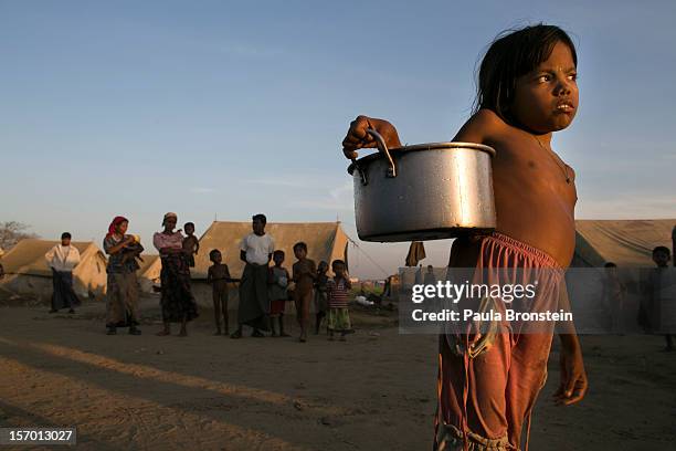 Young Rohingya girl carries water to her tent at a IDP camp November 24, 2012 on the outskirts of Sittwe, Myanmar. An estimated 111,000 people were...