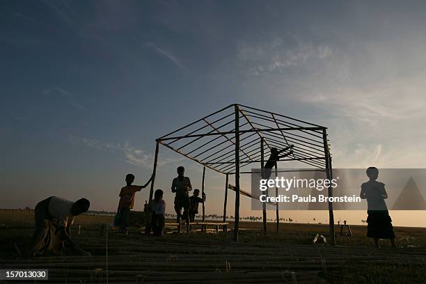 Rohingya family constructs a new house at an IDP camp November 24, 2012 on the outskirts of Sittwe, Myanmar. An estimated 111,000 people were...