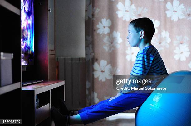 watching tv with my pilates ball - kid watching tv stock-fotos und bilder