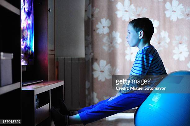 watching tv with my pilates ball - boy watching tv stock pictures, royalty-free photos & images