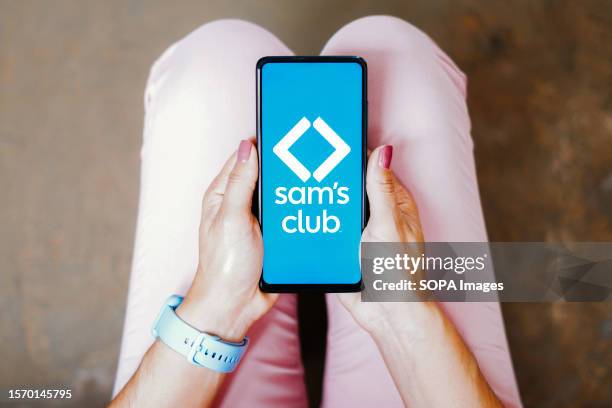 In this photo illustration, the Sam's Club logo is seen displayed on a smartphone screen,.