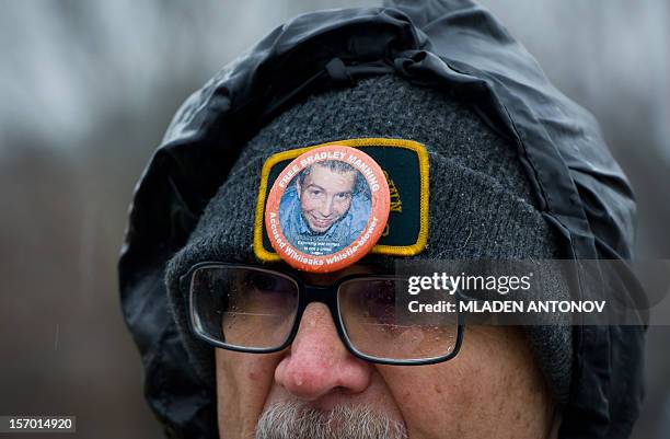 Protester from the Bradley Manning Support Group stands under the rain during a rally at the entrance of Fort George G. Meade military base in Fort...