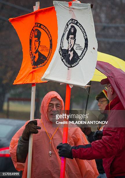 Members of the Bradley Manning Support Group protest under the rain during a rally at the entrance of Fort George G. Meade military base in Fort...
