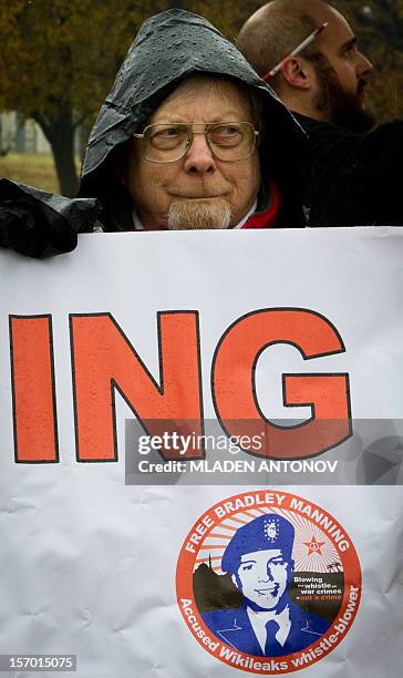 Member of the Bradley Manning Support Group holds a banner during a rally at the entrance of Fort George G. Meade military base in Fort Meade,...