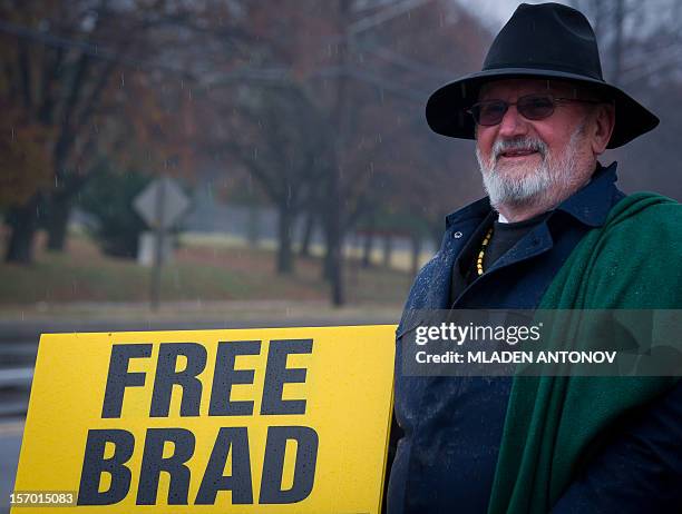 Member of the Bradley Manning Support Group holds a banner during a rally at the entrance of Fort George G. Meade military base in Fort Meade,...