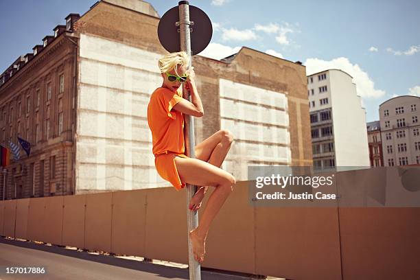 a young woman climbing in the city - pole foto e immagini stock