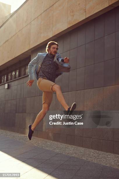 a trendy man jumping powerfull in the air - people in air stock pictures, royalty-free photos & images