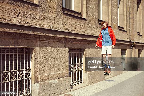 a caucasian man jumping through the city - in de lucht zwevend man stockfoto's en -beelden