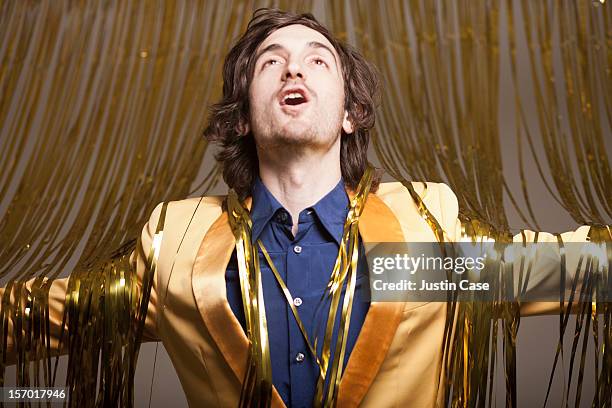 a man stepping through a golden curtain - singing stock-fotos und bilder