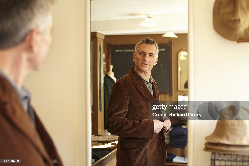 Man trying jacket in made to order clothes shop