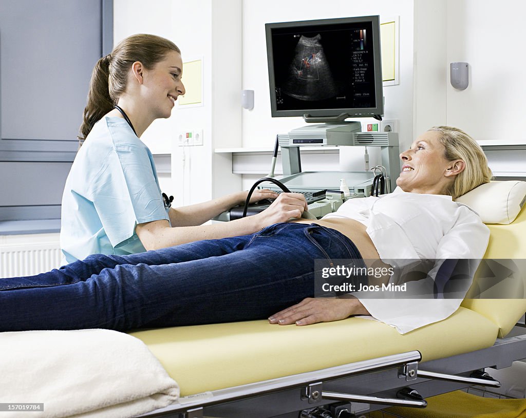 Woman receiving ultasound examination, smiling
