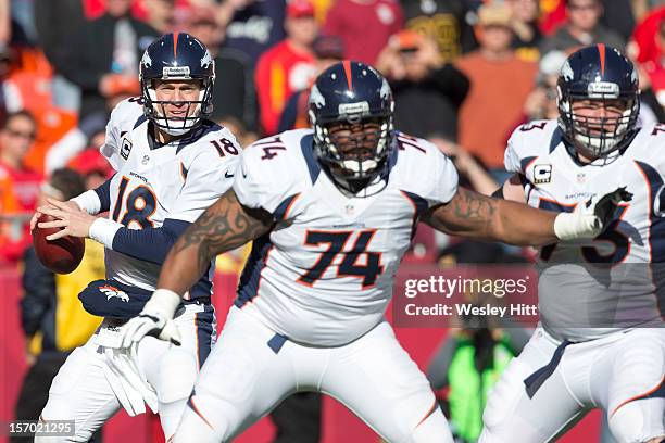 Peyton Manning of the Denver Broncos drops back to pass behind the protection of Orlando Franklin and Chris Kuper during a game against the Kansas...