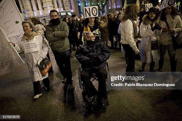 Man is pushed in a wheelchair amid health workers during a demonstration held on the second day of a two-day general strike on November 27, 2012 in...