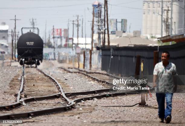 Person walks along railroad tracks as heat waves shimmer amid the city's worst heat wave on record on July 25, 2023 in Phoenix, Arizona. While...