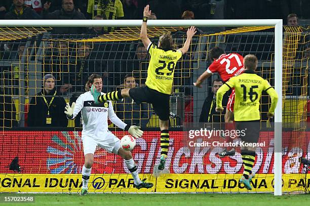 Stefan Reisinger of Duesseldorf scores the first goal against Roman Weidenfeller, Marcel Schmelzer and Jakub Blaszczykowski of Dortmund during the...