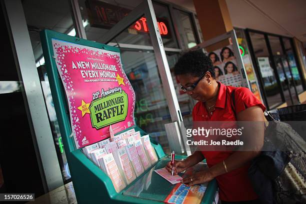 Debra Bea fills out her Powerball numbers as she buys tickets at Circle News Stand on November 27, 2012 in Hollywood, Florida. The jackpot for...