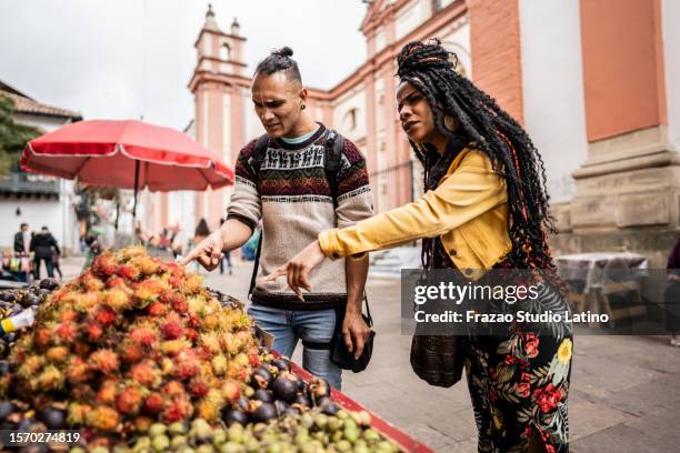 friends buying fruits in a street market in the in historic district of bogota, colombia - la candelaria bogota stockfoto's en -beelden