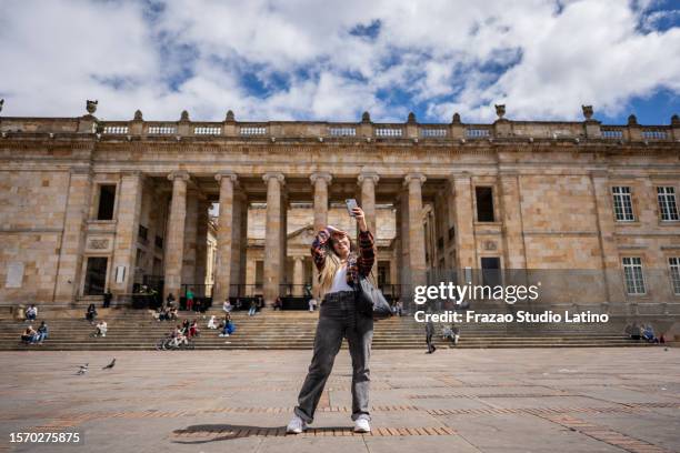 mittlere erwachsene frau, die ein selfie im historischen viertel von bogota, kolumbien, macht - bolivar square bogota stock-fotos und bilder